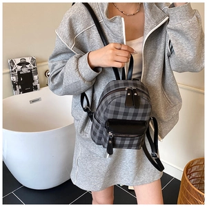 Mini-Rucksack mit Streifenmuster und schwarzer Ledertasche, modisch am Model präsentiert