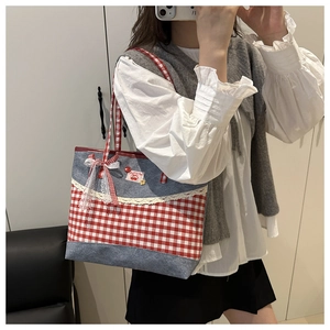 Détail du sac cabas en toile à carreaux rouges avec patchwork en jean et dentelle blanche