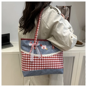 Détail du sac cabas à carreaux rouges avec bordure en dentelle blanche et patchwork denim