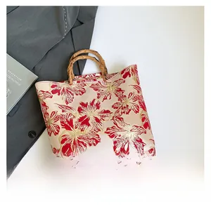 Detail of red floral jacquard fabric and natural bamboo handle on a retro tote bag
