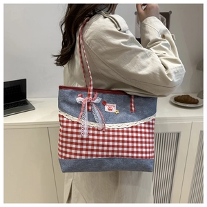 Gros plan d'un sac cabas en toile à carreaux rouges avec dentelle et motif cerise