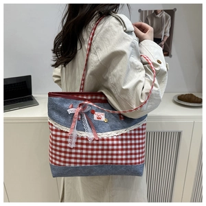 Détail du sac cabas en toile à carreaux rouges avec patchwork denim et dentelle