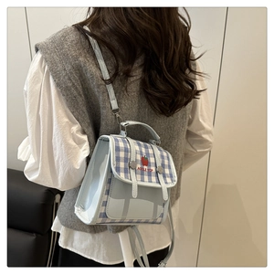 Detail of light blue checkered mini backpack showing apple embroidery and back carrying style