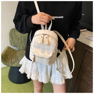 Details des Retro-Karo-Mini-Rucksacks mit Doppelreißverschluss und Seitentasche am Modell
