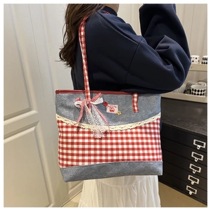 Détail du cabas à carreaux rouges avec dentelle, écusson cerise et patchwork de denim