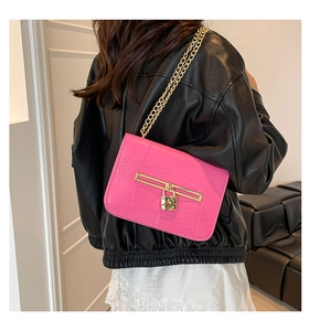 Detail of rose pink crocodile pattern bag with gold chain strap and metal lock buckle