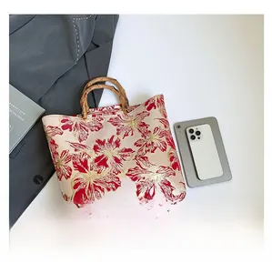 Detail of red floral jacquard fabric and natural bamboo handle on a retro tote bag