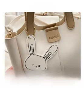 Détail du sac à main en cuir PU blanc cassé avec breloque lapin et logo de mode