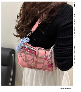 Pink Y2K shoulder bag with silver chains and blue checkered bow detail on model