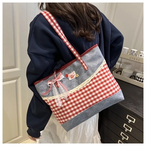 Détail du sac cabas en toile à carreaux rouges avec broderie cerise et bordure en dentelle