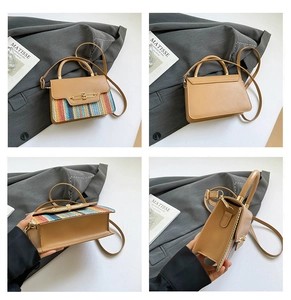 Detail view of khaki woven leather handbag with gold bar lock and adjustable strap