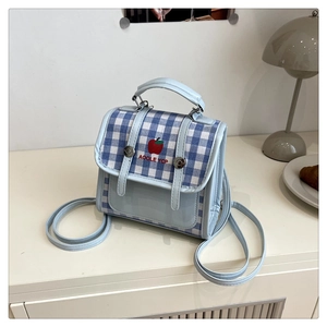 Detail of blue gingham backpack featuring red apple embroidery and slim straps
