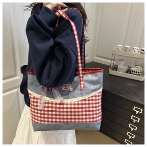Détail du sac cabas en toile à carreaux rouge et blanc avec dentelle et motif cerise