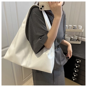 Close-up of a white glossy PU leather hobo bag showing its soft texture and large capacity