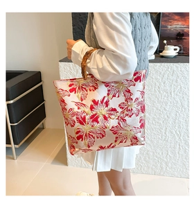 Detailed close-up of double-sided floral embroidery and a natural bamboo handle on a tote bag