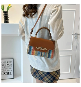 Detail of colorful rainbow knit pattern and brown leather flap with metal buckle