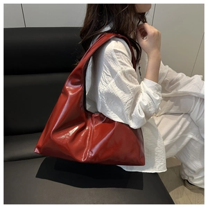 Chic dark red glossy faux leather hobo bag styled with a minimalist white outfit