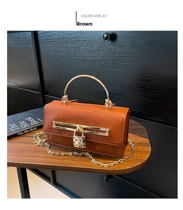 Details der Handtasche mit Krokodilmuster, goldenem Griff und Herz-Vorhängeschloss