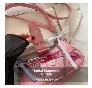 Close-up of magnetic metal buckle on pink Y2K shoulder bag with silver hardware