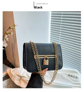 Detail of black faux leather bag with crocodile texture and gold heart-shaped lock clasp