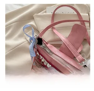 Close-up of smooth silver zipper closure on a pink punk style handbag with metal studs