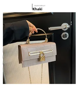 Detail der khakifarbenen Krokodil-Handtasche mit goldenem Griff und herzförmigem Schloss