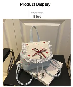 Close-up of light blue bow backpack with white lace edges and silver heart pendant