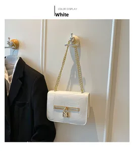 White faux crocodile skin handbag featuring gold chain strap and heart padlock detail
