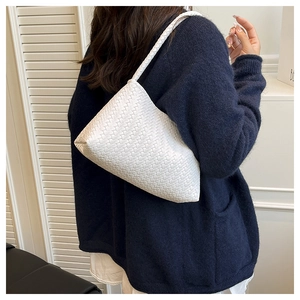 Detail of white woven texture on minimalist handbag with elegant leather craftsmanship