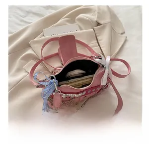 Detail view of the pink suede shoulder bag interior showing capacity for wallet and makeup