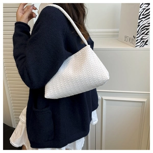 Detailed close-up of the woven texture on this white minimalist underarm shoulder bag