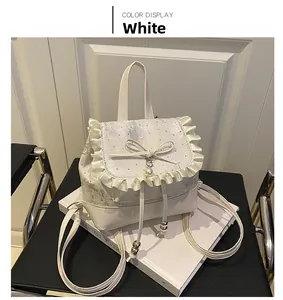 Close-up of white silk backpack with floral embroidery, lace edges and pearl bow detail