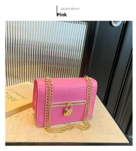 Detail of pink croc-embossed small square bag with chunky gold chain and heart padlock