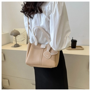 Détail du sac à main beige avec breloque lapin et bandoulière imprimée mode