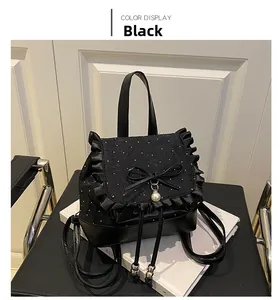 Detail of black backpack with polka dot fabric, lace trim, silk bow and pearl pendant
