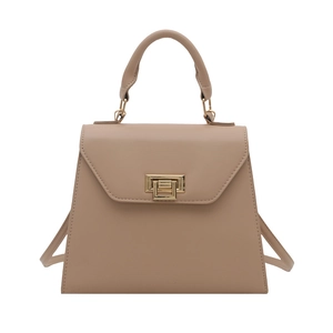 Minimalist beige Kelly handbag with gold hardware and top handle in a sleek trapezoid design