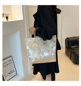 Detailed texture of golden floral jacquard fabric on tote bag with bamboo handle