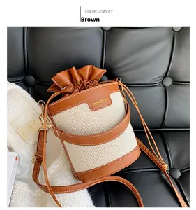 Detail of two-tone bucket bag featuring brown leather and beige fabric drawstring