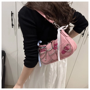 Pink Y2K shoulder bag featuring silver star rivets and a blue checkered bow charm
