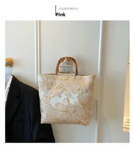 Detailed close-up of pink floral jacquard tote bag with natural bamboo top handle