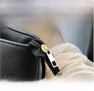 Détail d'un sac cabas en cuir noir à motif litchi avec fermeture éclair dorée de qualité