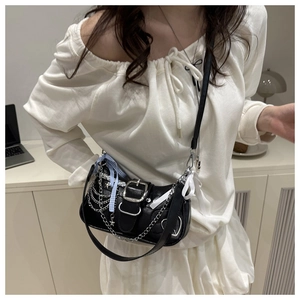 Detail of black vintage shoulder bag with silver chains and blue plaid ribbon bow