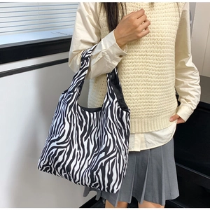 Detail van canvas draagtas met zebraprint, ruim interieur en brede comfortabele riem