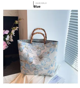Detail of vintage blue jacquard tote bag with traditional bamboo handles and floral patterns