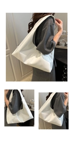 Detail of white glossy leather tote bag showing hobo silhouette and seamless shoulder strap