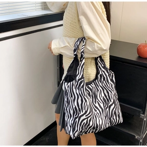 Grote zebrapatroon tote bag gedragen op de schouder door model voor dagelijks gebruik