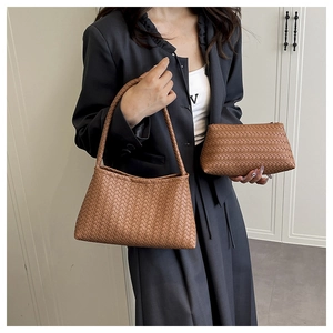 Detail of woven leather tote bag set in caramel brown with matching zipper pouch