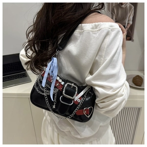 Y2K punk shoulder bag detail with silver chains, star rivets and a blue bow ribbon