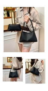 Detail of black woven leather texture on stylish shoulder bag and matching pouch
