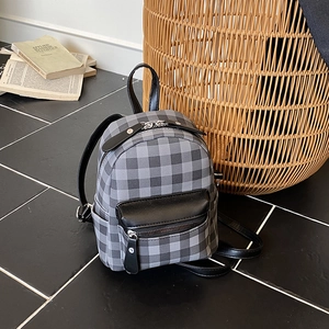 Mini Rucksack mit grauem Karomuster, schwarzen Ledertaschen und minimalistischem Design